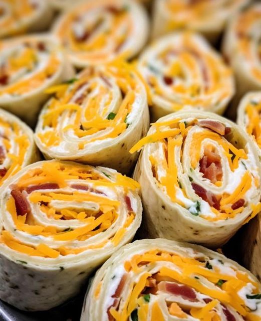 Creamy Chicken Roll-Ups: Sliced pinwheels on white platter, garnished with green onions