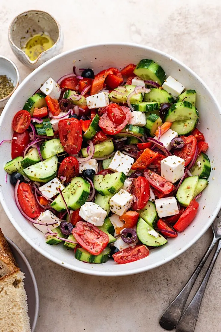 bowl filled with Vegan Greek Salad Fresh vegetables, vegan feta, tangy dressing